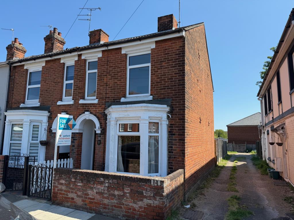 Lot: 116 - END-TERRACE HOUSE WITH PARKING - Front elevation and side access road to parking area